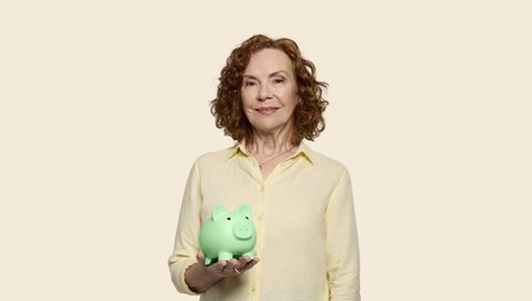 Woman holding a green piggy bank
